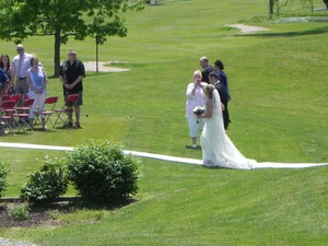 Bride walking along a sunlit course path