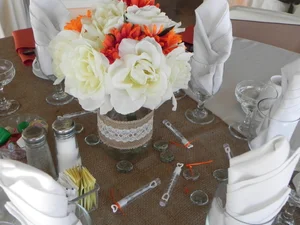 Rustic burlap centerpiece with white and orange flowers