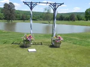 Outdoor wedding ceremony at the arbor beside the pond with golf course and mountain views