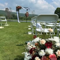 Ceremony aisle lined with flowers and mountain views behind the arbor