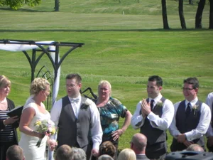 Wedding party gathered at the arbor during ceremony