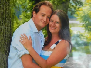 Engagement portrait of a couple by a tree on the golf course