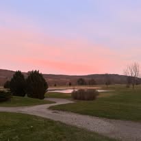 Sunset sky over the course pond and winding cart path
