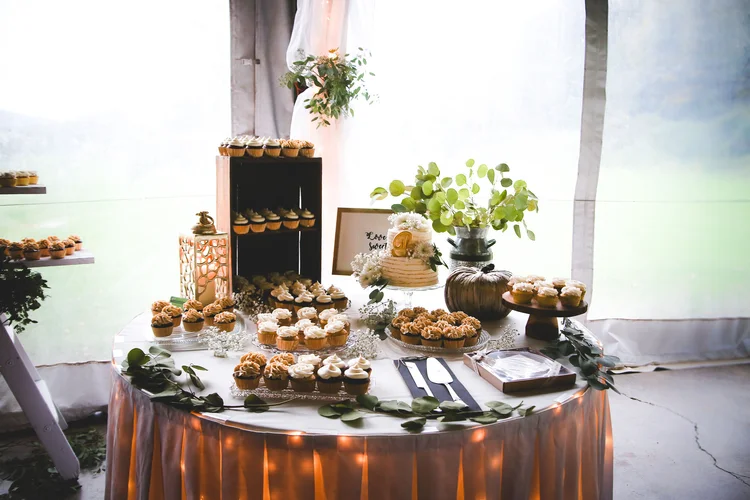 Rustic cupcake display with greenery accents