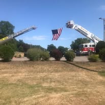 Fire trucks displaying American flag at a patriotic community event on the course