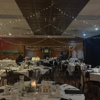 Lodge banquet room with string lights and formal table settings