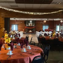 Lodge banquet room decorated for fall with orange tablecloths and autumn centerpieces