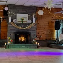 Lodge fireplace with string lights and dance floor setup