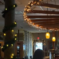 Lodge ceiling beam wrapped in holiday lights and greenery