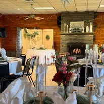 Lodge set for a wedding reception with flower arrangements near the fireplace