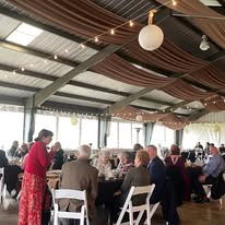 Pavilion event with brown ceiling draping and guests dining