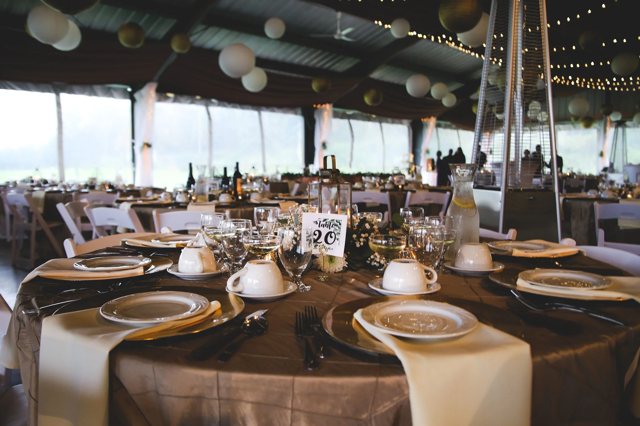 Gold tablescape under string lights in the pavilion
