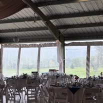Pavilion set with white chairs and draping overlooking the course