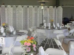 White table settings with lattice and flowers in the pavilion