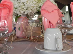 Mason jar centerpiece with pink flowers in a rustic style