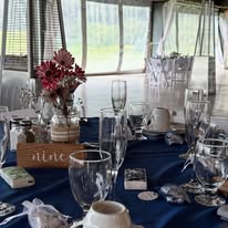Navy tablescape with wooden table number and red flower arrangement