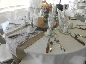 Rustic table setting with burlap runner and wildflower centerpiece