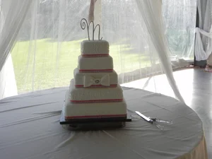 White tiered wedding cake displayed in the pavilion